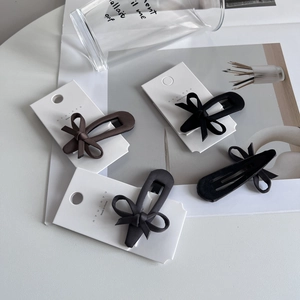Elegant fabric bow hair clips in black, grey, and coffee brown on a display card
