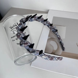 Close-up of blue plaid braided headband with non-slip teeth and handmade metal tag