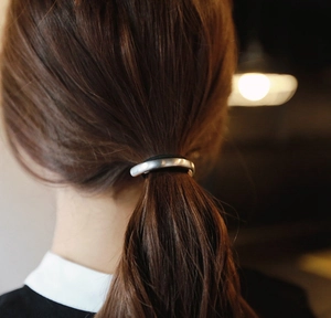 Close-up of minimalist silver matte metal semi-circle hair tie worn on a ponytail