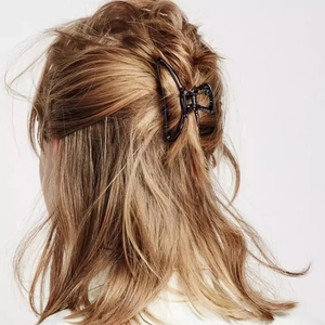 Vue arrière du modèle portant une grande pince à cheveux géométrique noire élégante