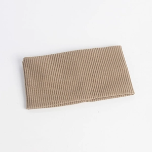 Detailed view of light camel ribbed knit headband with elastic texture and soft fabric