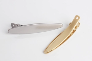 Detailed side view of matte gold and silver metal hair clips with non-slip grip teeth