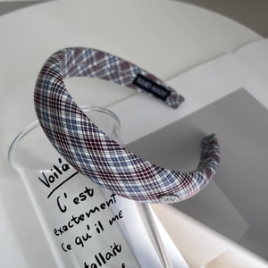 Detail of plaid fabric headband with handmade label and elegant metal button accent
