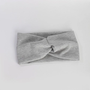 Gros plan du bandeau tricoté gris montrant la texture côtelée fine et le tissu élastique