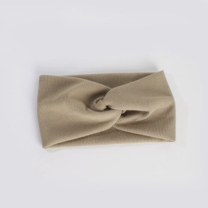 Gros plan du bandeau en maille côtelée kaki avec un design à nœud croisé chic