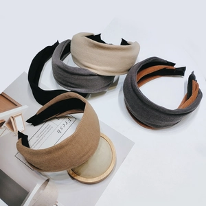 Macro detail of assorted wide knit headbands in neutral earth tones on white background