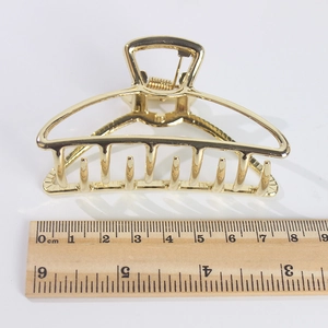 Pince à cheveux minimaliste en métal doré avec design en arc creux et mesure de 8,5cm