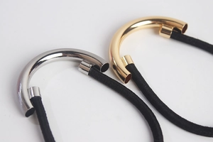 Detail of minimalist gold and silver semicircular hair ties with elastic bands