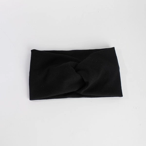 Gros plan détaillé d'un bandeau en tricot noir avec un nœud central et texture côtelée