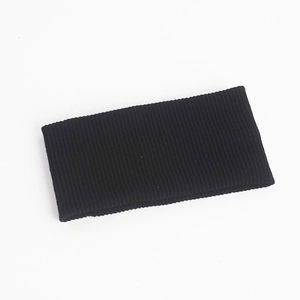 Macro detail of black knitted headband featuring vertical ribbed texture and elastic fabric