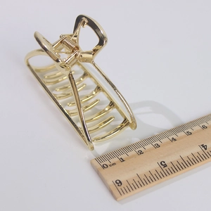 Vue détaillée de la pince à cheveux rectangulaire en métal doré de 8cm avec règle