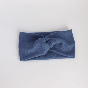 Détail d'un bandeau en maille bleue avec un nœud torsadé et une texture côtelée