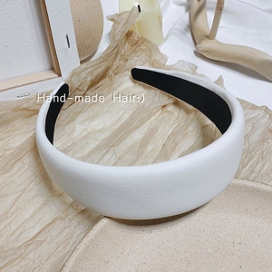 Détail d'un serre-tête large en cuir grainé blanc avec doublure intérieure velours