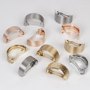 Macro shot of curved metal hair clips featuring brushed finishes and spring clip textures