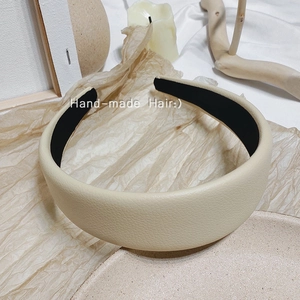 Détail d'un serre-tête large en cuir litchi crème au style minimaliste chic