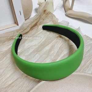 Détail d'un serre-tête en cuir grainé vert avec doublure intérieure noire antidérapante