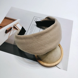 Detail shot of beige knitted wide headband with soft texture and black inner fabric lining
