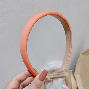 Close-up of orange-pink padded headband with fine texture and anti-slip lining