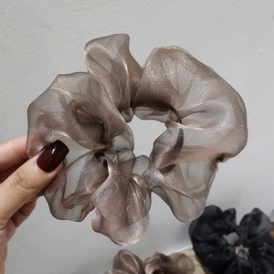 Detail of a large bronze organza scrunchie with metallic luster and wavy texture edges