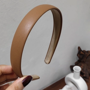 Close-up of brown litchi pattern leather headband with non-slip beige inner lining