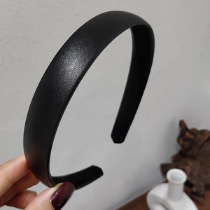 Detail shot of black litchi pattern leather headband with premium textured surface