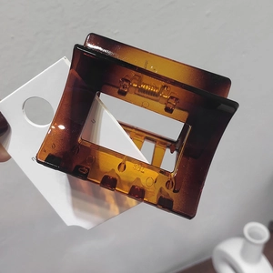 Macro shot of an amber tortoiseshell hair claw clip with geometric hollow square design