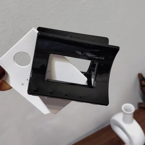 Detail of glossy black square hair claw clip with minimalist hollow structure and spring