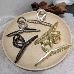 Lot de 5 grandes pinces à cheveux en métal doré argenté et noir sur une plaque céramique