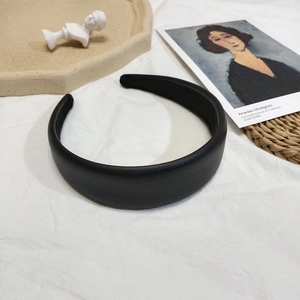 Vue détaillée d'un serre-tête en cuir noir sur fond minimaliste de style français