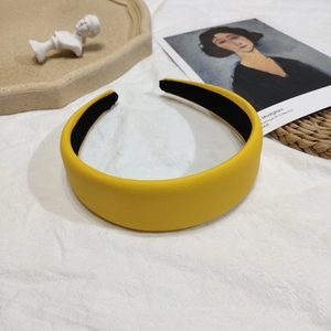 Gros plan sur serre-tête en cuir litchi jaune avec design français épais et rembourré