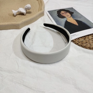 Vue de dessus du serre-tête large en cuir blanc avec surface texturée et doublure noire