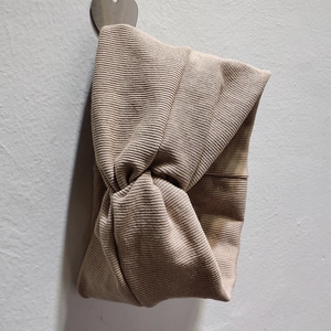 Détails du bandeau en maille côtelée kaki avec design croisé sur un crochet mural