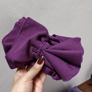 Dettaglio della trama della fascia in maglia a coste viola intenso con cuciture fini