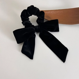 Detail of a French velvet black bow scrunchie with soft texture and elegant retro design