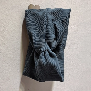 Gros plan sur un bandeau en tricot côtelé large avec nœud croisé bleu gris foncé