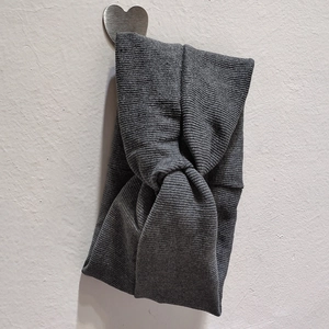 Détail du bandeau en maille grise avec un nœud central torsadé et texture côtelée