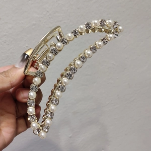 Détail de la pince à cheveux en alliage doré ornée de perles et de strass brillants