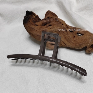 Grande pince à cheveux marron foncé de style coréen minimaliste sur fond en lin naturel