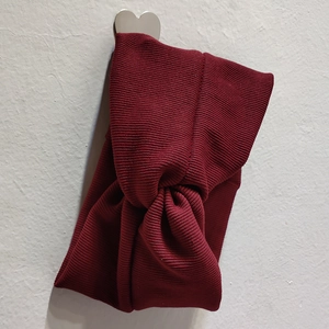 Texture détaillée du bandeau en maille bordeaux avec un élégant nœud croisé chic