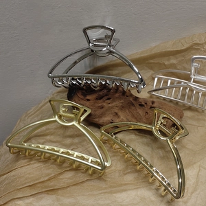 Detail of metal hair claw clips in polished and matte gold and silver finishes