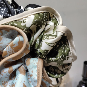 Detail of satin fabric scrunchies with floral prints and contrast edge stitching