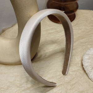 Detail eines gepolsterten Champagner-Satin-Haarreifs mit rutschfestem Samtfutter