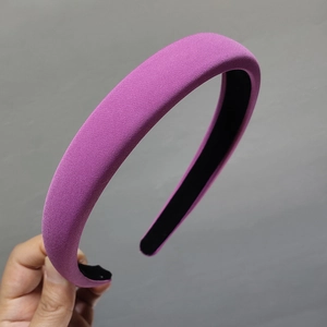 Detail of a thick padded purple headband with a textured fabric finish and black lining