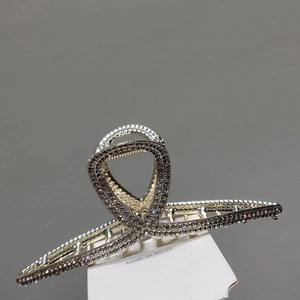 Vue macro détaillée d'une pince à cheveux de luxe en métal doré avec strass et design croisé