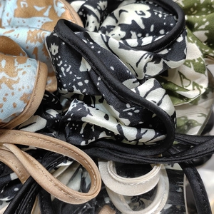 Macro shot of assorted silk scrunchies with floral prints and detailed stitching edges
