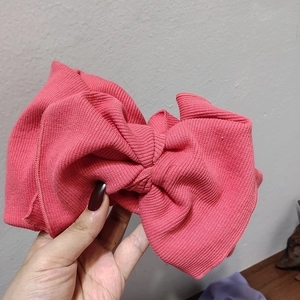 Pink oversized ribbed knit bow headband with elastic stretch for versatile winter hair styling