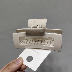 Close-up of a cream rectangular hollow hair claw clip with Made in Korea card