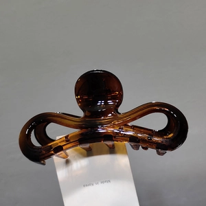 Détail d'une pince à cheveux en résine ambrée avec un mécanisme à ressort métallique fort