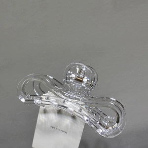 Vue détaillée d'une grande pince à cheveux en acrylique transparent avec design ondulé