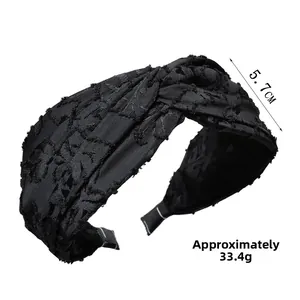 Detail shot of black twisted headband showing the 5.7cm width and textured fabric